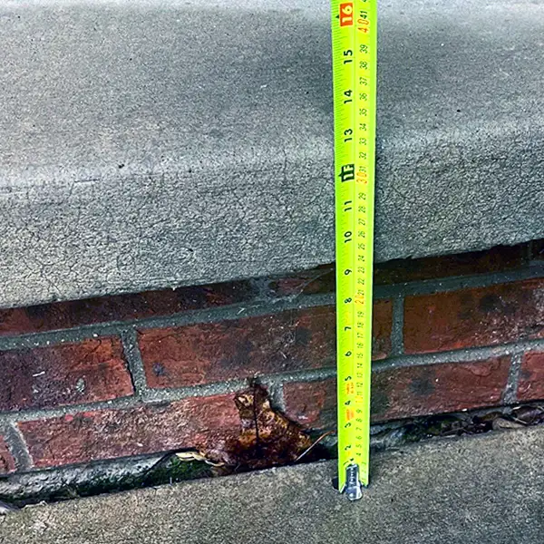 Concrete step with measuring tape, indicating precise measurements for accurate leveling.